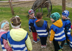 Dzieci stoją przy wybiegu z zebrami